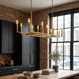 Modern kitchen with a gold chandelier, dark cabinets, and a large window.