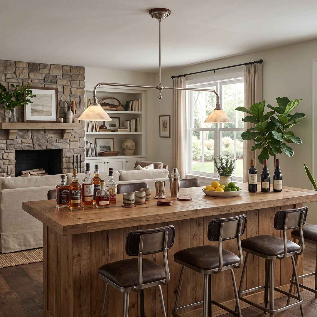 A pendant light with two glowing alabaster shades hangs above a rustic wooden bar beside a stone fireplace.