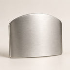 Front view of the stainless steel finger guard showing the smooth outer face the knife slides against