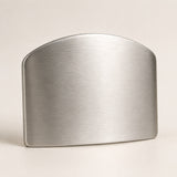 A brushed metal accessory with a rounded top and flat front, shown on a plain light beige studio background.