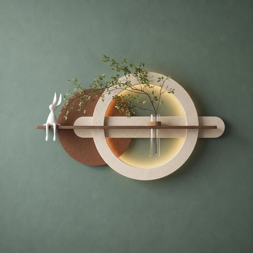 Backlit plaster ring wall art on a sage green wall with a walnut shelf and glass bud vase