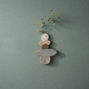 Wabi sabi stacked pebble wall art on a sage green wall with faux stems