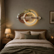 Backlit plaster ring wall art above a bed in a warm neutral bedroom