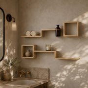 Pine cube and ledge shelves on a bathroom wall above a stone basin