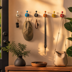 Colorful ceramic adhesive hooks holding keys and accessories in an entryway
