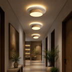 Travertine wood flush mount ceiling lights glowing in an evening hallway