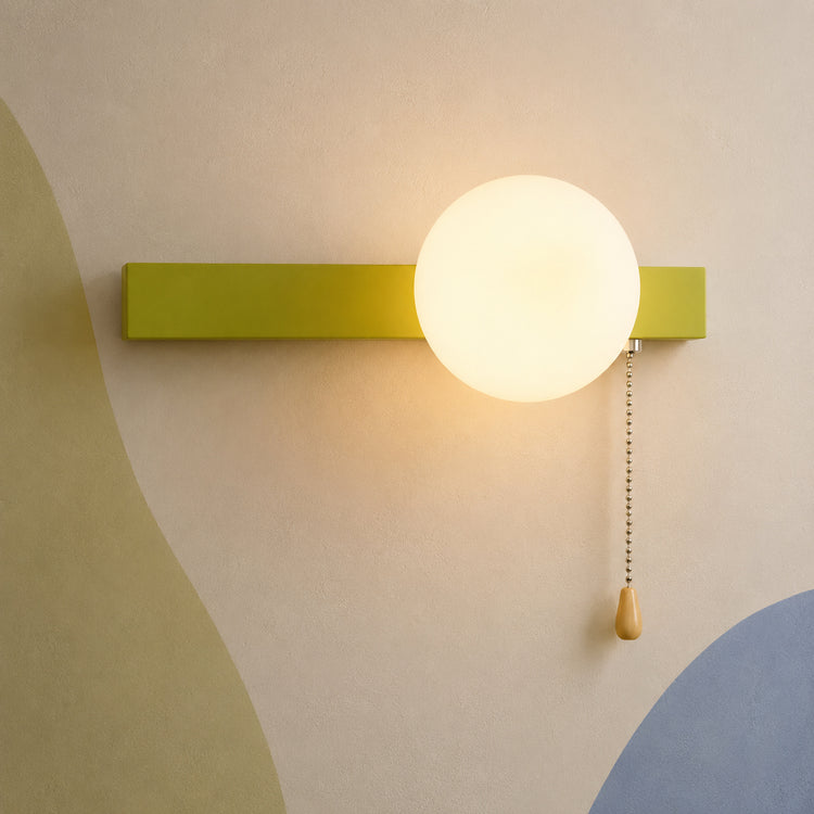 Chartreuse green bar globe wall sconce lit warm with pull chain switch