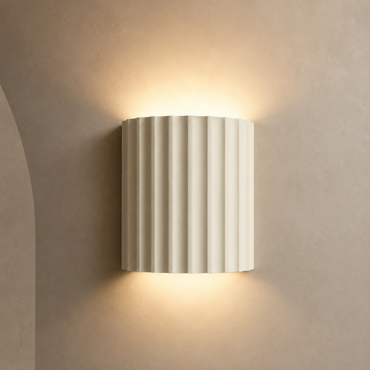 Ivory fluted up down wall sconce lit warm on a greige wall