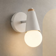 White exposed bulb wall sconce lit on a stone wall with cream arch