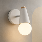 White exposed bulb wall sconce lit on a stone wall with cream arch