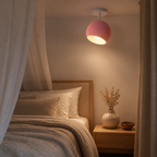 Pink modern ball ceiling light glowing in a bedroom at night