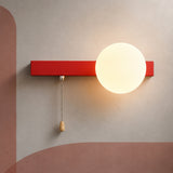 Coral red bar globe wall sconce lit warm with pull chain switch
