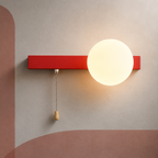 Coral red bar globe wall sconce lit warm with pull chain switch