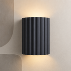 Dark charcoal fluted up down wall light on a stone wall
