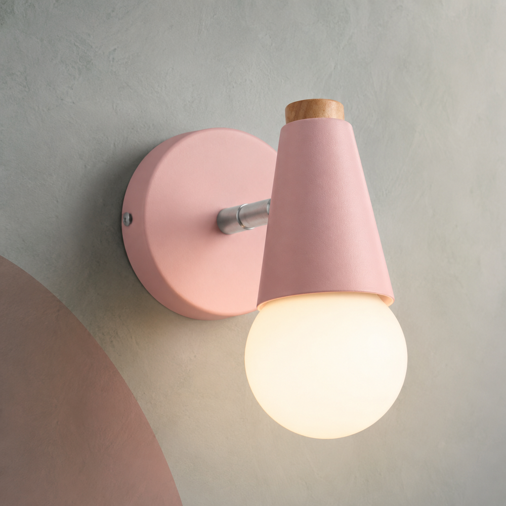 Pink small wall sconce lit warm on a gray wall with blush shapes