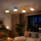 Four colorful ball ceiling light variants glowing in a real lounge ceiling