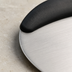 Macro of the brushed steel blade edge and the moulded handle bond on a bench scraper