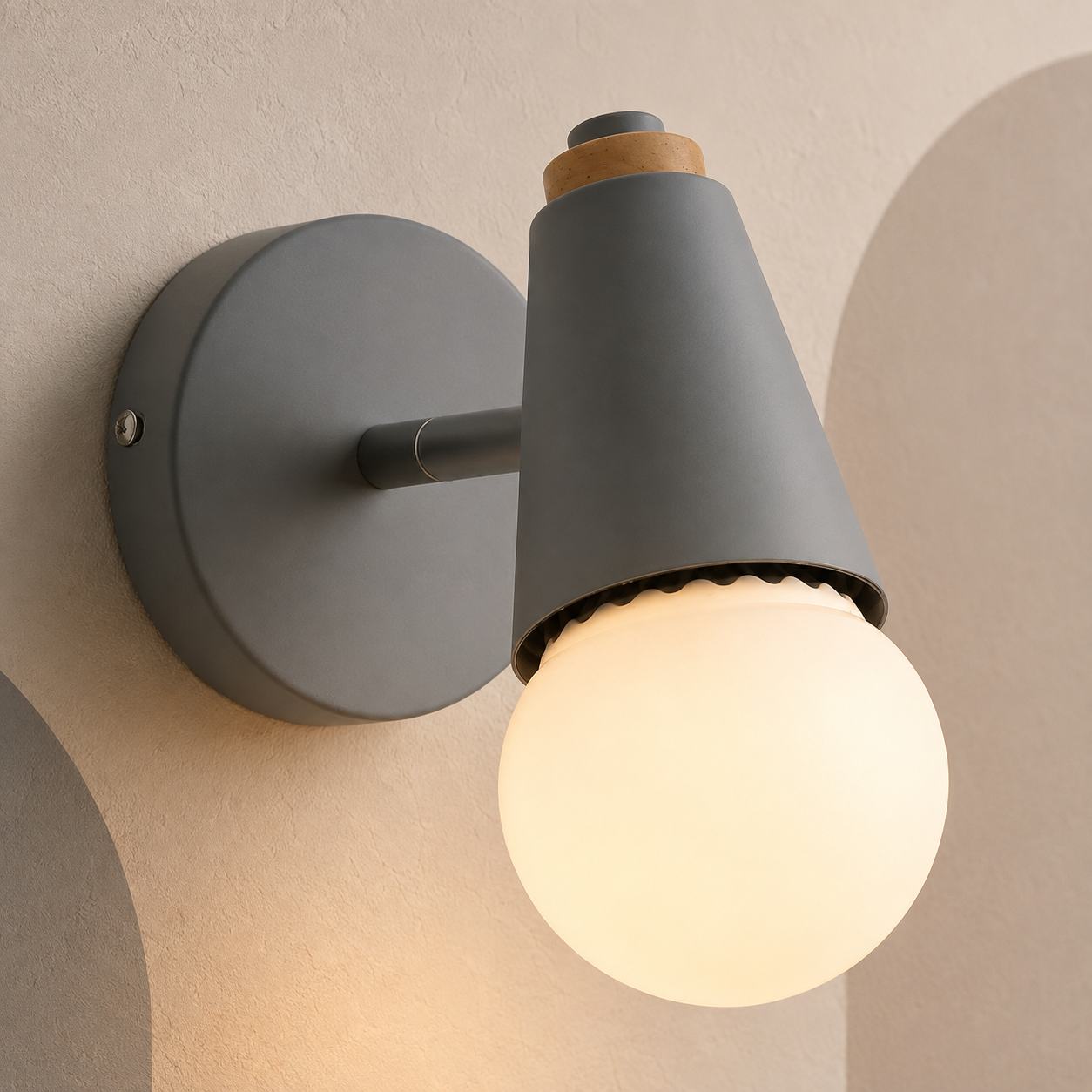 Gray globe vanity sconce lit on a cream wall with soft arches