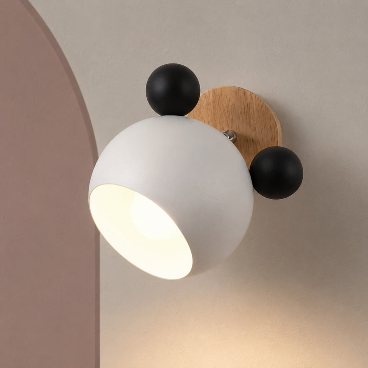 White and black bear wall sconce lit on a warm wall with dusty rose arch