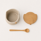 Ceramic jar, bamboo lid, and bamboo spoon laid flat, what's included