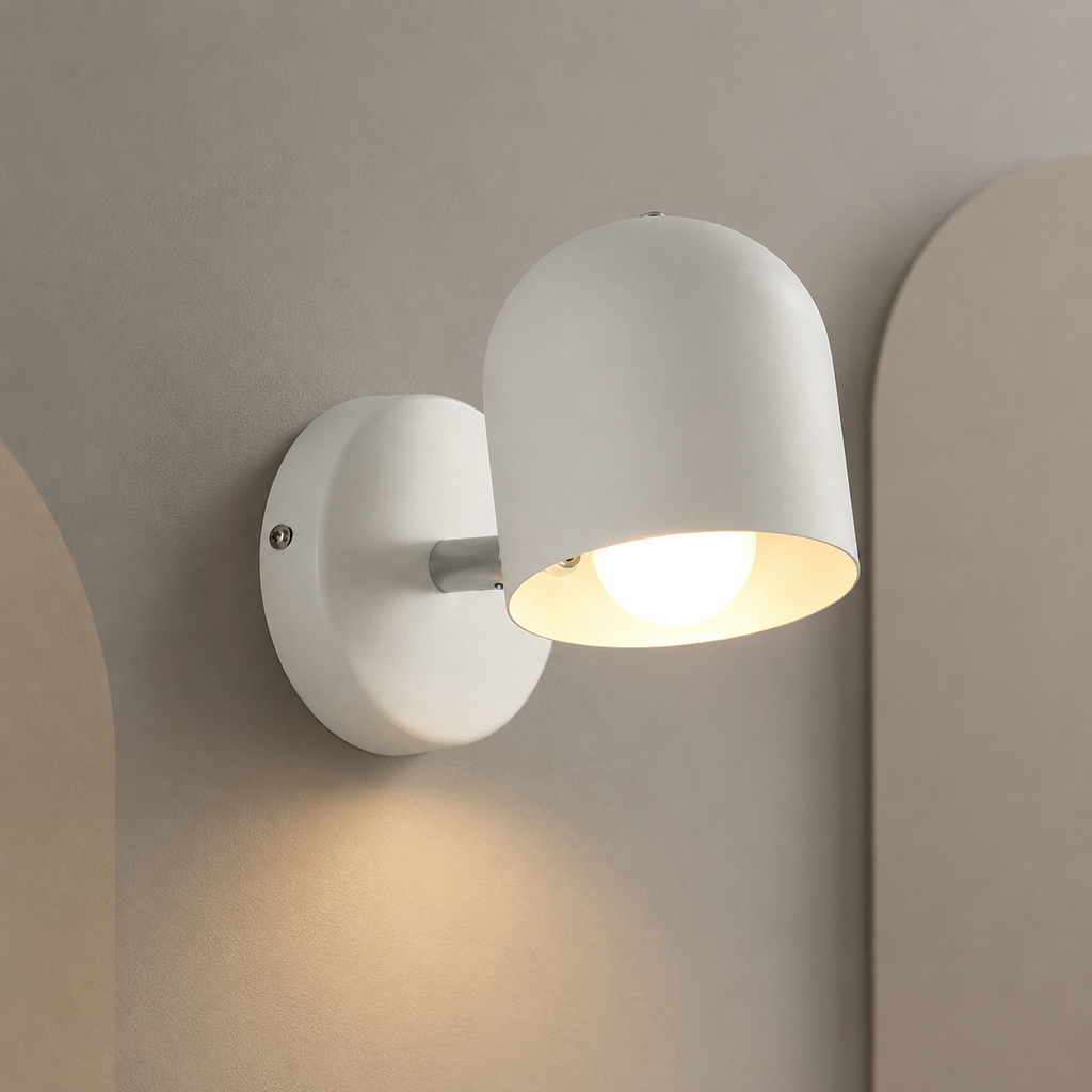 White dome wall lamp lit warm on a greige wall with arches