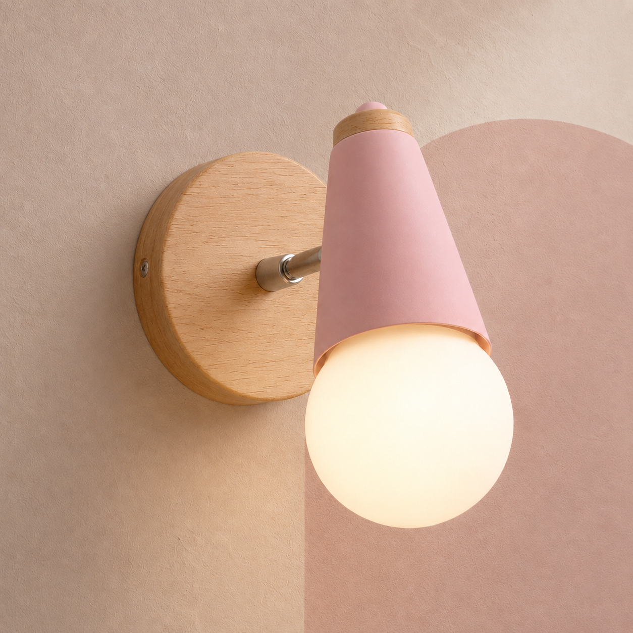 Pink wall sconce with wood backplate lit warm on a rose wall