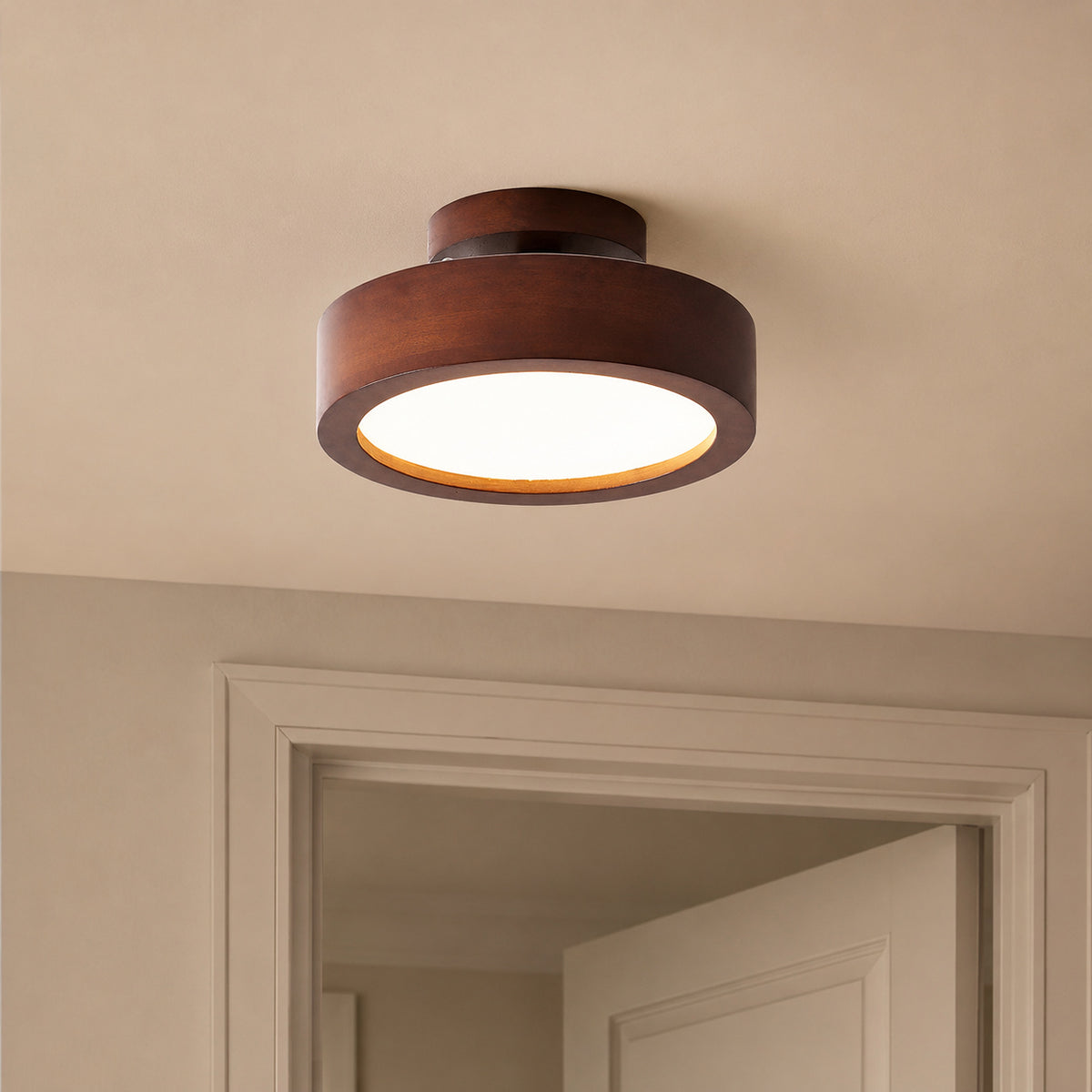 A modern semi-flush mount ceiling light with a dark brown wood-grain outer ring and a glowing white frosted glass shade, installed on a beige ceiling above a doorway.