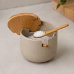 Bamboo spoon scooping coarse salt from the open ceramic jar