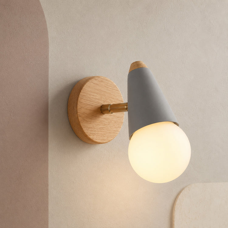 Gray wall sconce with rubberwood backplate lit on a taupe wall