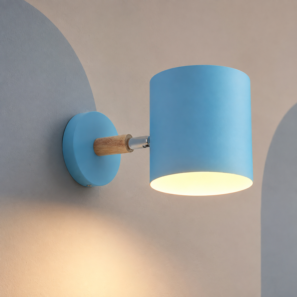 Blue cylinder bedside wall sconce lit on a putty wall