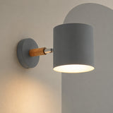 Gray cylinder wall lamp on wood arm lit on a mushroom wall