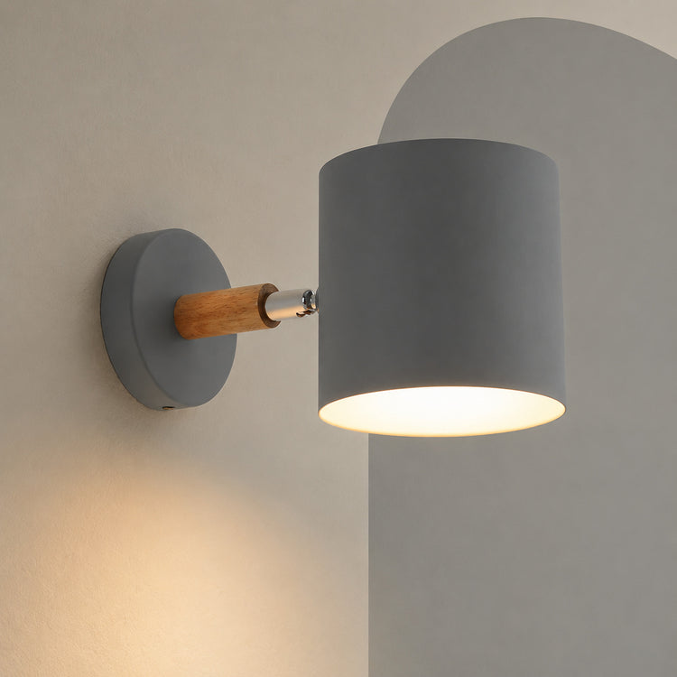 Gray cylinder wall lamp on wood arm lit on a mushroom wall