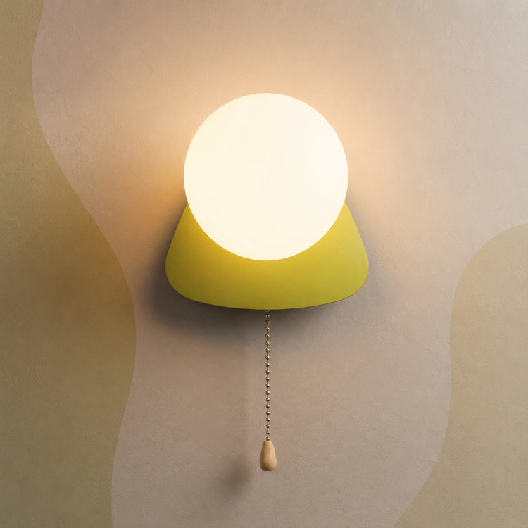 Chartreuse green pebble globe wall sconce lit warm with pull chain switch