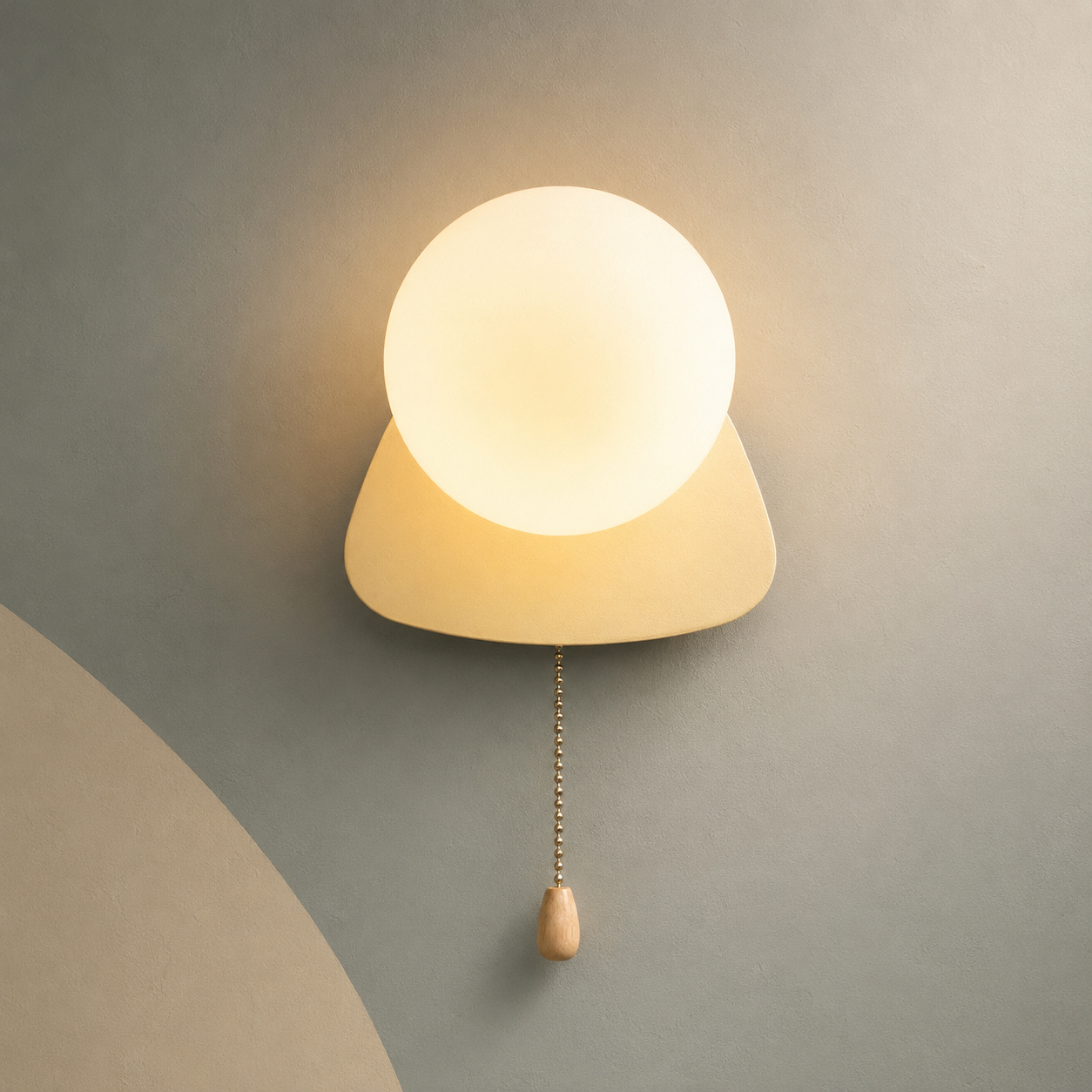 Soft beige pebble globe wall sconce lit warm with pull chain switch