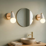 Two white globe vanity sconces with wood backplates flanking a round bathroom mirror