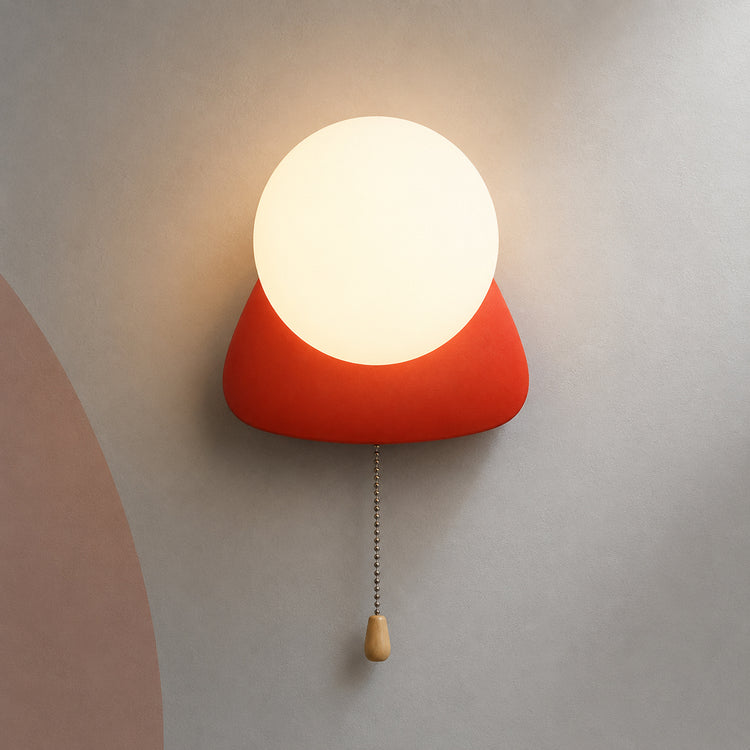 Coral red pebble globe wall sconce lit warm with pull chain switch