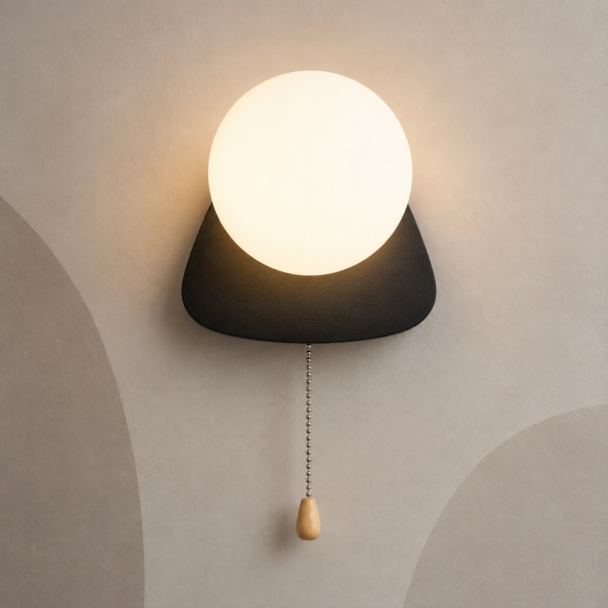 Matte black pebble globe wall sconce lit warm with pull chain switch