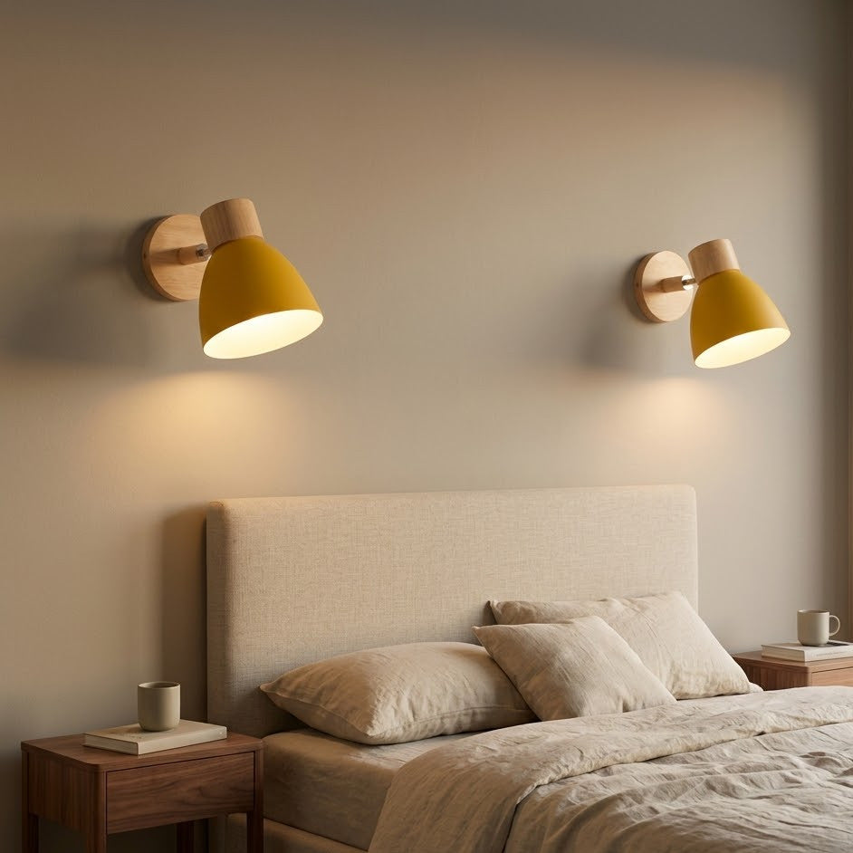 Pair of yellow bell macaron wall sconces flanking a bed above walnut nightstands
