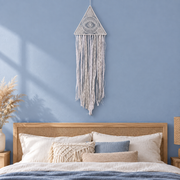 Boho bedroom above a rattan bed, hoop, moon or eye triangle, fine knotted and crocheted cord, wrapped hoop or frame