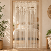 Macrame door curtain hung in a wooden bedroom door frame with a bed beyond