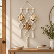 Macrame hat rack holding three straw hats above an entryway console