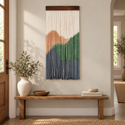 Portrait dip dye landscape wall hanging above a wooden bench in an entryway