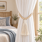Beaded macrame tie back holding a white curtain in a farmhouse bedroom