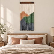 Dip dyed landscape wall hanging above a headboard with terracotta bedding