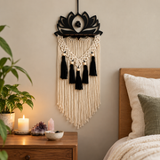 Lotus wall hanging above a bedside table with candles and small crystals