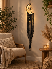 Charcoal moon dream catcher hung beside an armchair in a reading nook