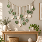 Leaf garland above an oak console with plants in a sunlit boho living room