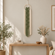 Green leaf vine wall hanging above a light wood console in a boho living room