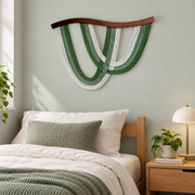 Green rope arc wall hanging above a single dorm bed with green bedding
