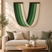 Green U swag wall hanging above a cream sofa in a sunlit living room